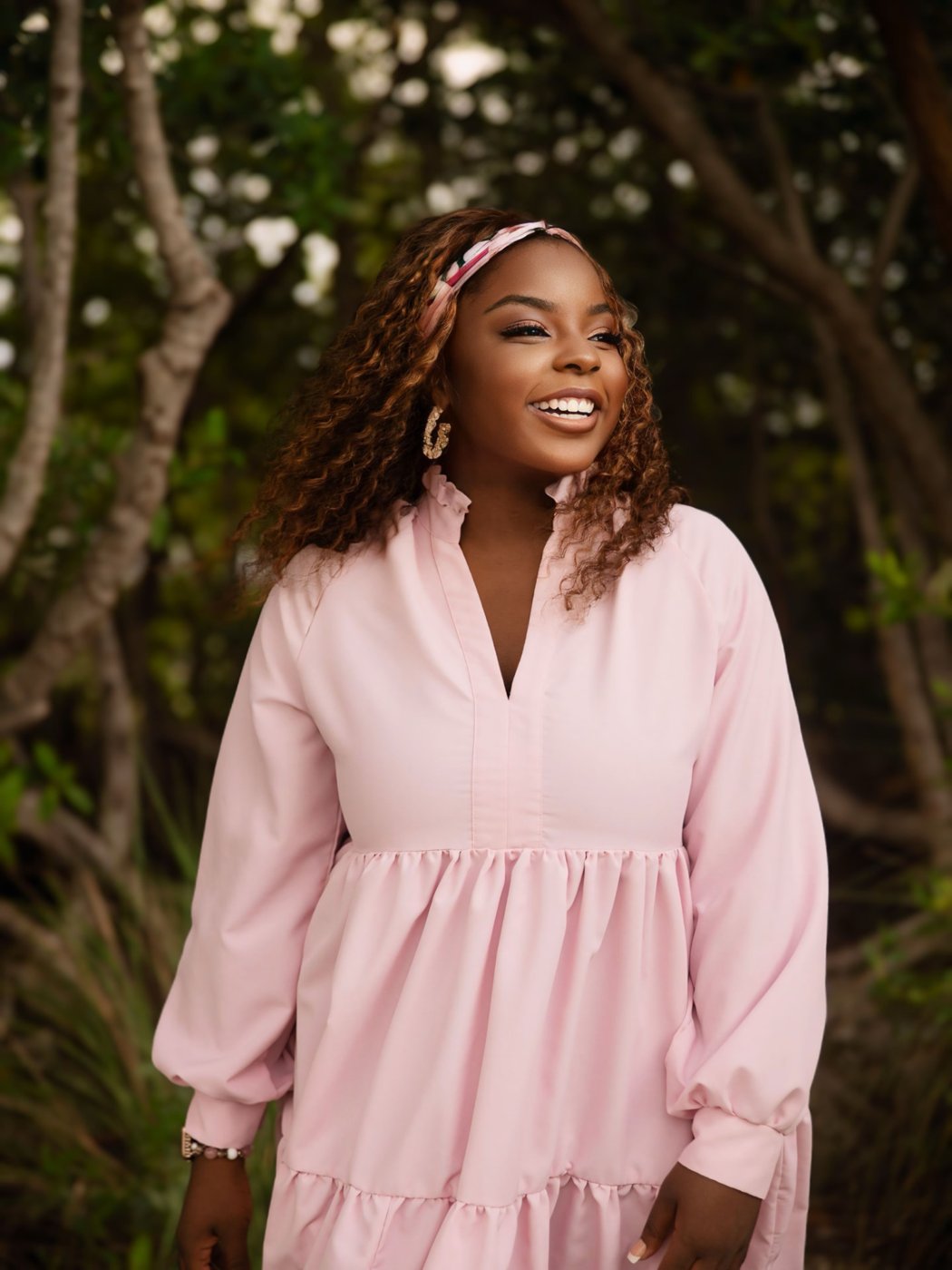 Monica Tookes smiling in a blush dress